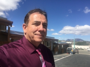 Len DeJoria, Catholic Charities Community Engagment Coordinator in front of apartments.