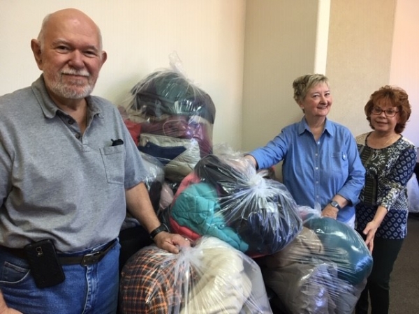 Victoria and Jeff Morhous bring donations to JoAnn Williams, Catholic Charities office manager in Prescott.